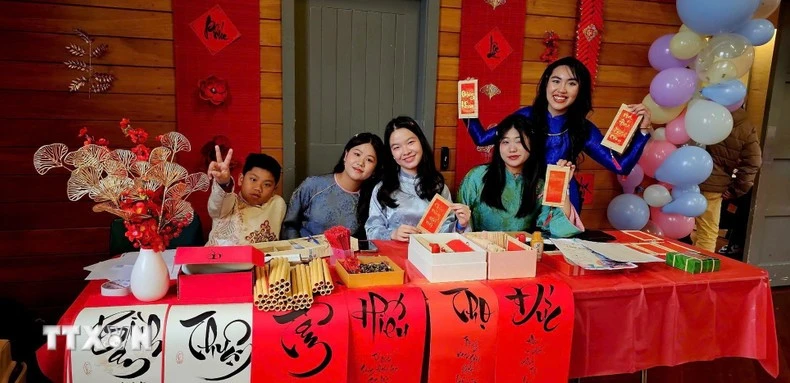A calligraphy booth draws young Vietnamese at the gathering. (Photo: VNA)
