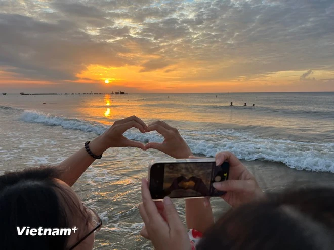 Tourists enjoy the sunrise moment in Mui Ne. (Photo: VNA)