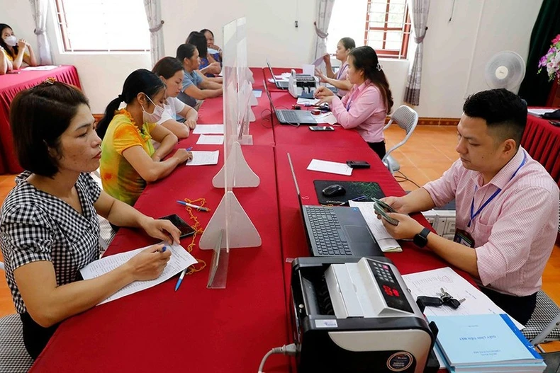 Immediately after the official launch of the two-tier local government model on July 1, the Vietnam Bank for Social Policies directed its provincial and municipal branches to promptly ensure convenient and seamless disbursement for the public. (Photo: VietnamPlus)