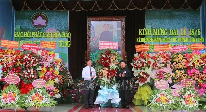 Bui Van Tang (left), Vice President of the Vietnam Fatherland Front Committee of An Giang province, extends congratulations at the grand ceremony marking the 86th founding anniversary of Hoa Hao Buddhism on June 13. (Photo: VNA)