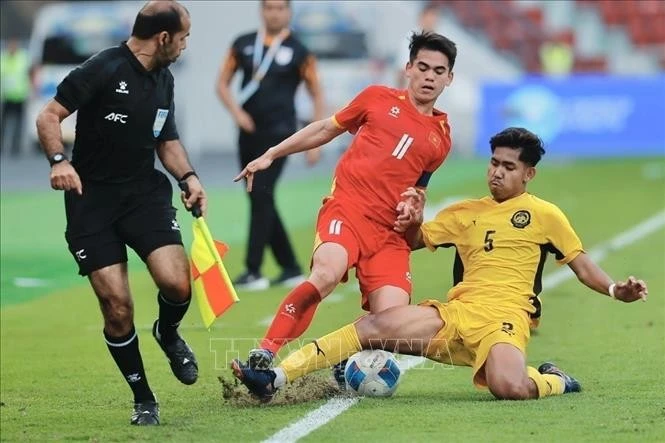 A U22 Malaysia player strives to stop Khuat Van Khang’s dribble. (Photo: VNA)