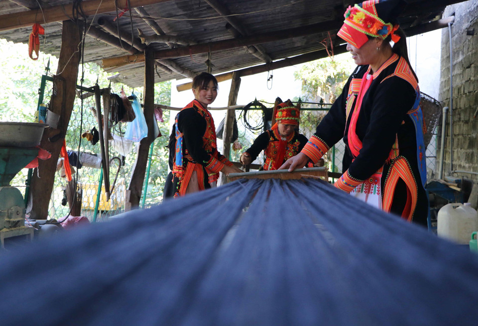 Shiny black threads create the distinctive costumes of Dao women. (Photo: Nguyen Oanh – VNA)