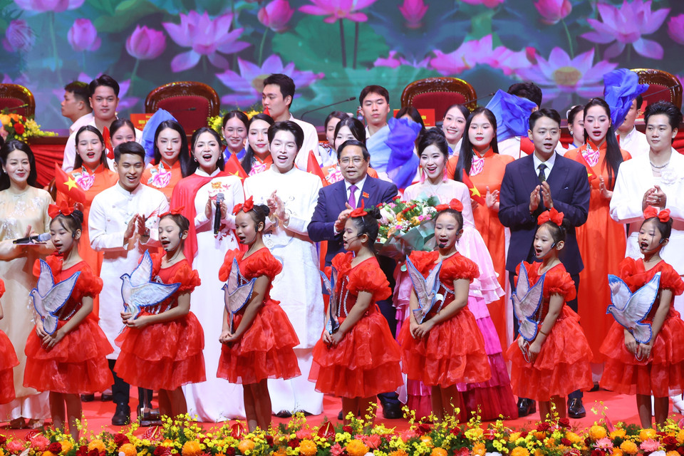 Politburo member, Secretary of the Party Committee, and Prime Minister Pham Minh Chinh presents flowers to artists performing at the Congress’s opening ceremony. (Photo: Van Diep - VNA)