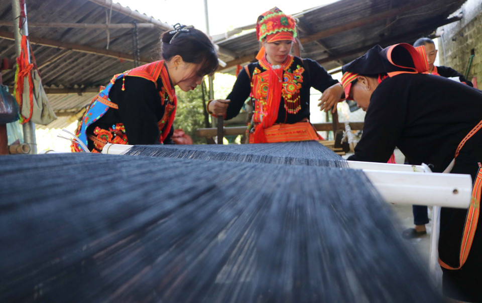 Dao women spin yarn and sew their own traditional costumes. (Photo: Nguyen Oanh – VNA)