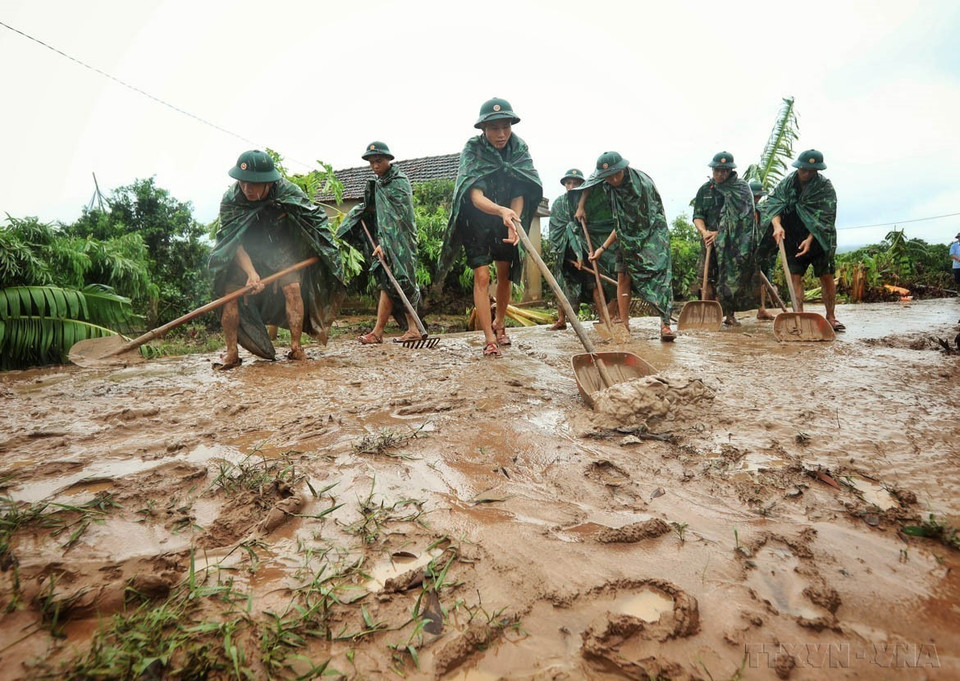Officers and soldiers from Division 325 help locals clean up mud in Kha La village, Tan Lap commune, Luc Ngan district, Bac Giang province after severe floods. (Photo: VNA)