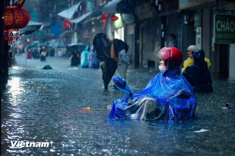 By evening, the rain continues to pour down right at rush hour, preventing water from draining off the streets. (Photo: Hoai Nam/Vietnam+)