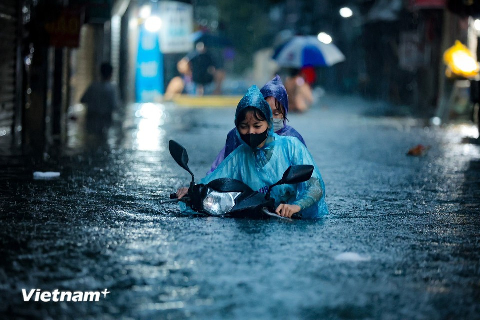 In some areas, water rises over one meter, submerging vehicles as people try to return home. (Photo: Hoai Nam/Vietnam+)