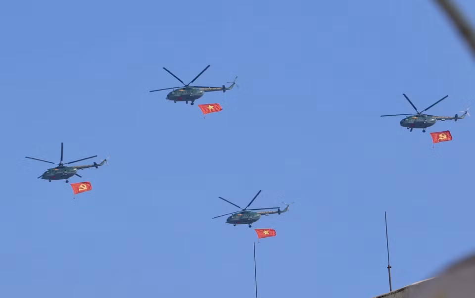 A helicopter formation carrying the Party flag and the national flag flies over the sky of downtown Ho Chi Minh City. Photo: Hong Giang - VNA