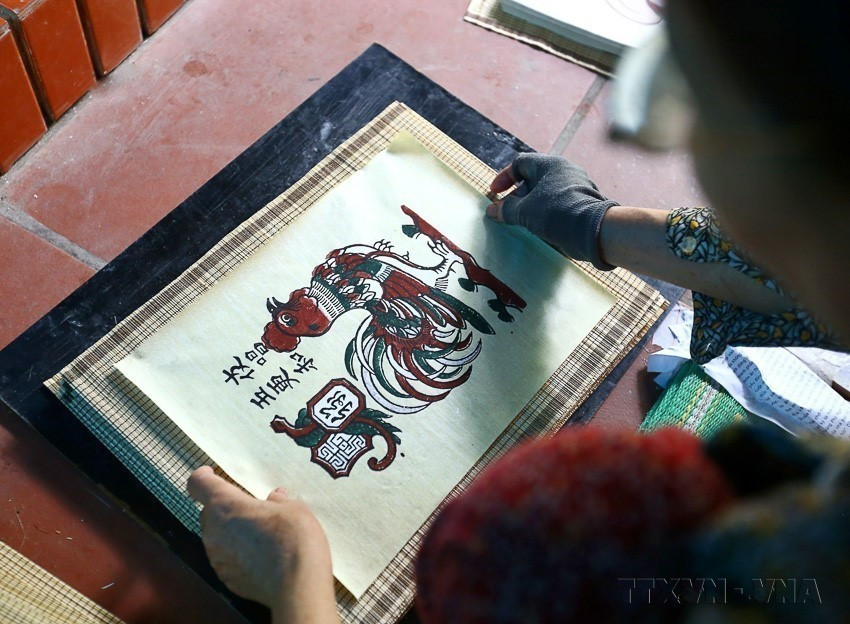 After printing, Dong Ho paintings are removed from the blocks, placed on bamboo trays, and dried in airy spaces. When dry, artisans continue printing subsequent colors, with the black outline always printed last. (Photo: Minh Quyet – VNA)