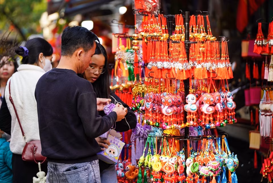 A young couple shops for home decorations during Tet. (Photo: Khanh Hoa – VNA)