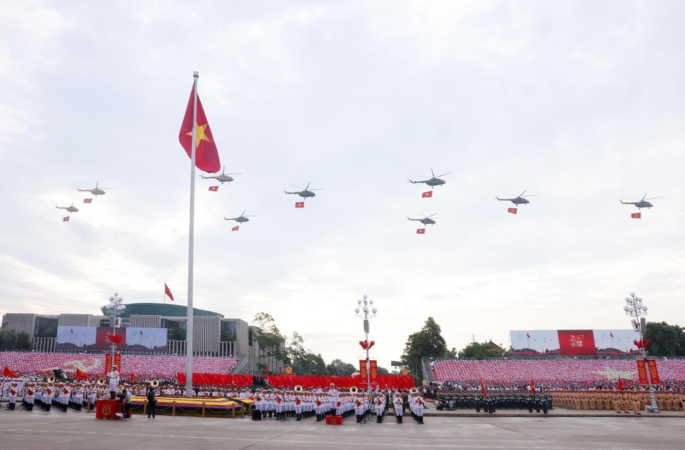 A formation of Mi-171, Mi-17, and Mi-8 helicopters carrying the Party flag and national flag flies over Ba Dinh Square. (Photo: Lam Khanh - VNA)