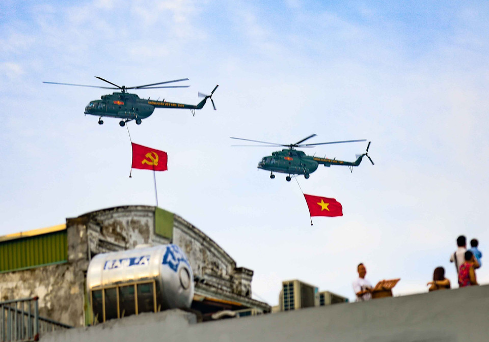 A formation of helicopters from the Vietnam People’s Air Force carrying the Party flag and national flag flies over the skies of Hanoi. Photo: Thanh Tung - VNA