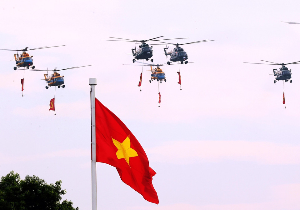 A formation of helicopters from the Vietnam People’s Air Force carrying the Party flag and national flag flies over Ba Dinh Square. (Photo: Van Diep - VNA)