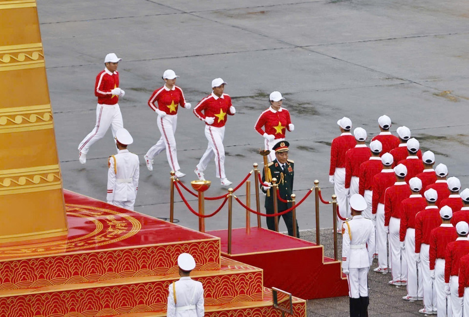 The program begins with the torch relay and the lighting of the ceremonial flame — a symbol of the aspirations of the Vietnamese people. The flame is handed to Lieutenant General Nguyen Duc Soat, Hero of the People’s Armed Forces and former Deputy Chief of the General Staff of the Vietnam People’s Army, who achieved outstanding feats by shooting down six enemy aircraft, becoming one of the heroic pilots of the Vietnam People’s Army. (Photo: Doan Tan - VNA)