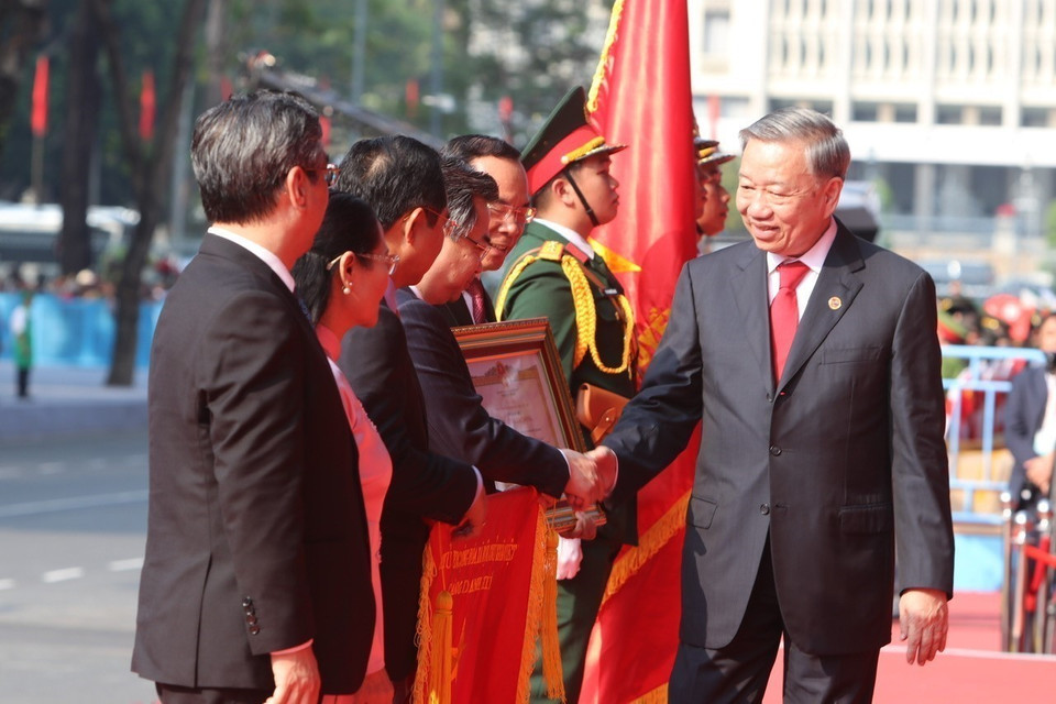 Party General Secretary To Lam, on behalf of the Party and State leadership, presents the title of "Labor Hero" to the Party Committee, Government, and People of Ho Chi Minh City. Photo: VNA