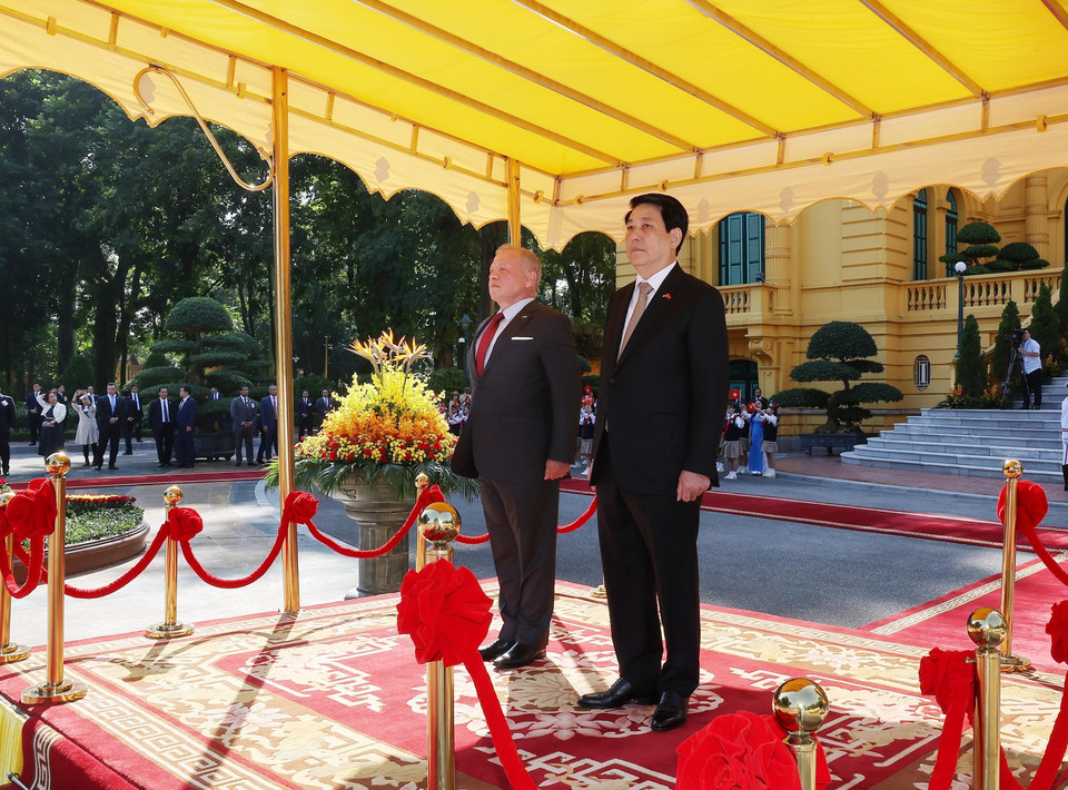 State President Luong Cuong and King Abdullah II ibn Al Hussein of the Hashemite Kingdom of Jordan stand on the reviewing stand as the military band plays the national anthems of both countries. (Photo: Lam Khanh – VNA)