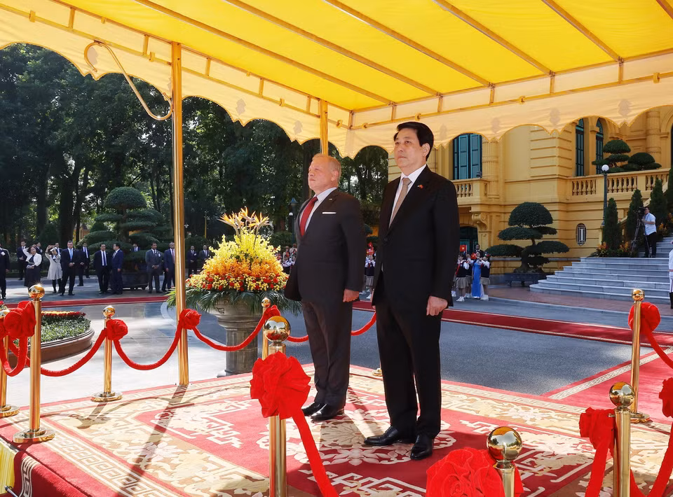 State President Luong Cuong and King Abdullah II ibn Al Hussein of the Hashemite Kingdom of Jordan stand on the reviewing stand as the military band plays the national anthems of both countries. (Photo: Lam Khanh – VNA)