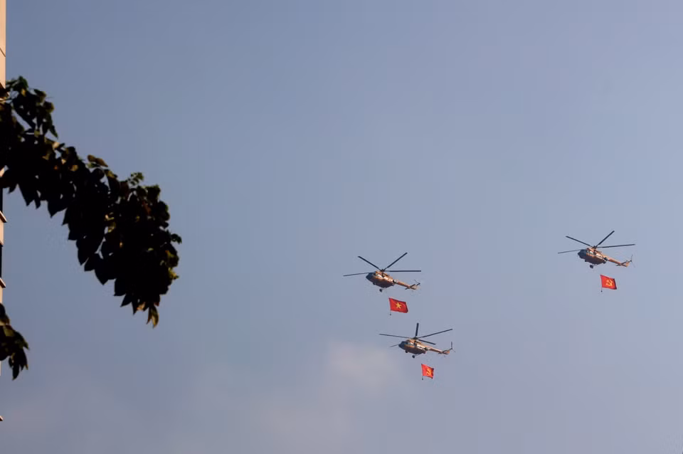 A formation of helicopters carrying the national flag performs in the sky over Ho Chi Minh City. Photo: VNA