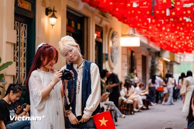 Each street corner in Hanoi is dressed in vibrant red and yellow, creating a festive atmosphere as the country commemorates the 50th anniversary of reunification. (Photo: Hoai Nam/Vietnam+)