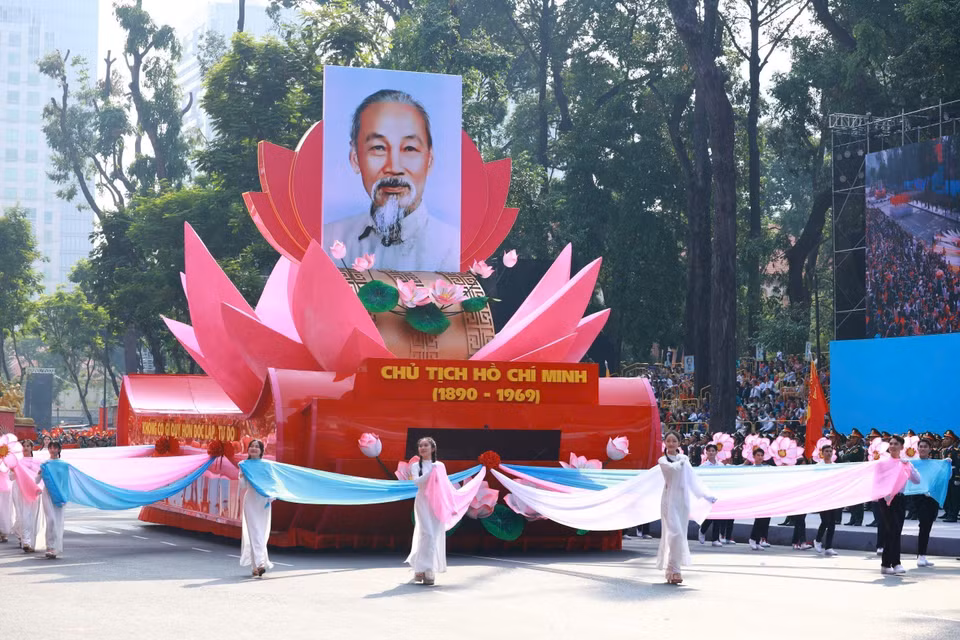 The parade begins with a formation of vehicles featuring the model of the National Emblem of the Socialist Republic of Vietnam and the vehicle carrying the portrait of President Ho Chi Minh passing the grandstand. Photo: VNA