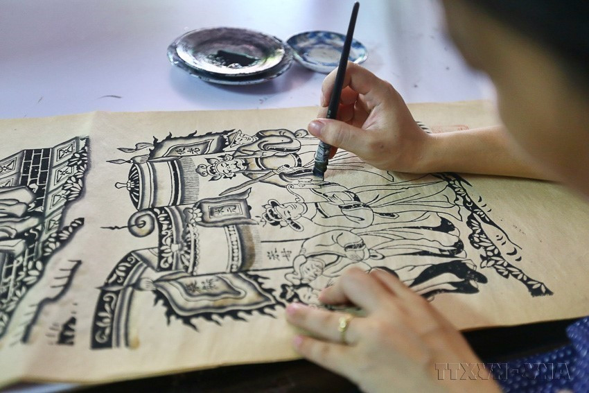 In addition to woodblock printing, large-format paintings are hand-painted. Creating new Dong Ho models is often the collective effort of the entire village across generations. (Photo: Minh Quyet – VNA)