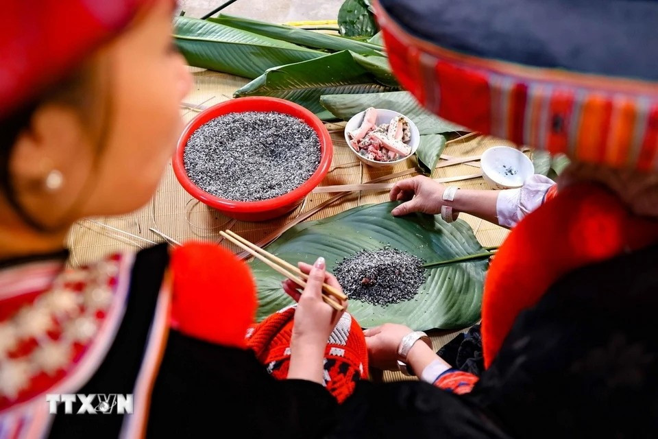 In Red Dao families, making "banh chung gu" is traditionally a woman’s task. Mothers and sisters pass down the skill, teaching the younger girls how to wrap the cakes. (Photo: Thanh Tung/VNA)