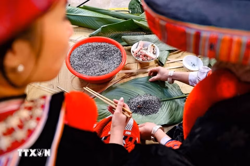 In Red Dao families, making "banh chung gu" is traditionally a woman’s task. Mothers and sisters pass down the skill, teaching the younger girls how to wrap the cakes. (Photo: Thanh Tung/VNA)