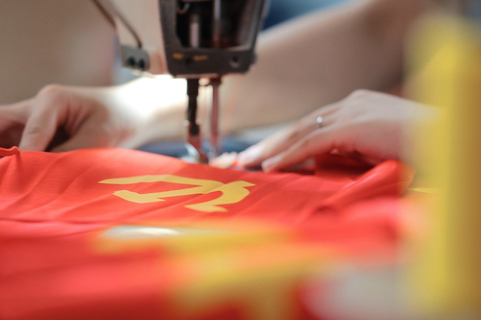 Sewing machines producing national flags and Party flags are running at full capacity. (Photo: VNA)