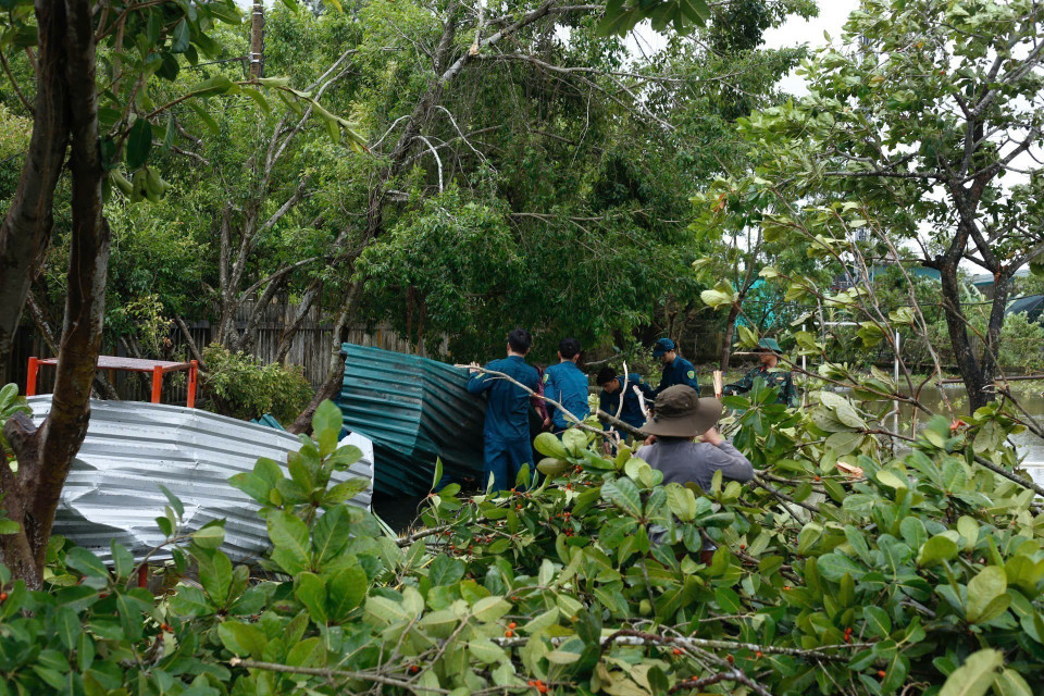 Local forces clear debris of metal roofs and fallen trees caused by Typhoon Bualoi. (Photo: Mai Trang – VNA)