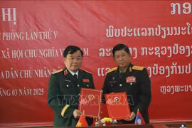 Deputy Defence Minister Senior Lieutenant General Hoang Xuan Chien (L) and his Lao counterpart Senior Lieutenant General Vongkham Phommakone exchange official minutes of the policy dialogue on March 28 (Photo: VNA)