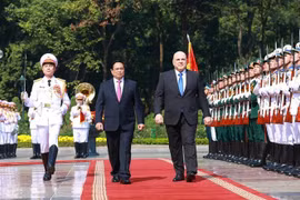 Prime Minister Pham Minh Chinh (L) and Russian Prime Minister Mikhail Vladimirovich Mishustin review the guard of honour of the Vietnam People's Army at the official welcome ceremony. (Photo: VNA)