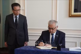 Deputy Chair of the Russian Federal Assembly’s Federation Council Committee on Foreign Affairs Bair Zhamsuyev writes in the book of condolence at the ceremony held by the Vietnamese Embassy in Russia. (Photo: VNA)