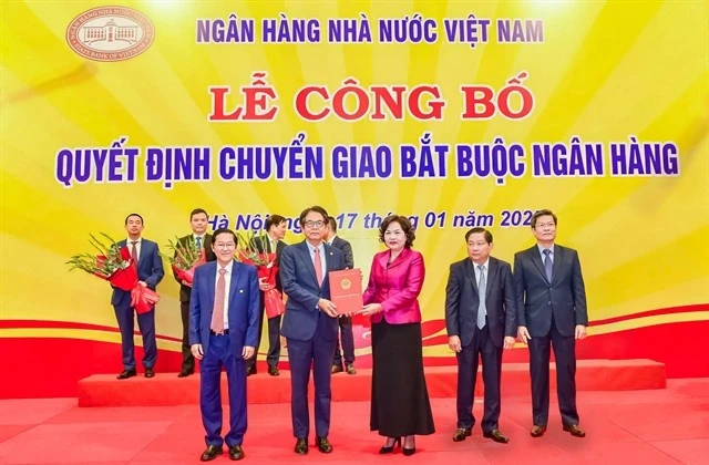 Nguyen Thi Hong, Governor of the State Bank of Vietnam, hands over the decision on the mandatory transfer of DongA Bank to Kim Byoungho, Chairman of the Board of Directors of HDBank in Hanoi on January 17. (Photo courtesy of HDBank)