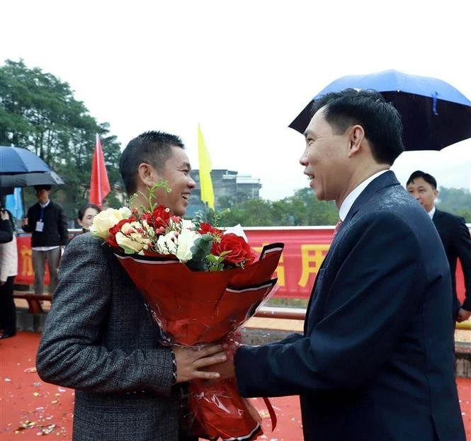 A leader of Binh Lieu district, Quang Ninh province, presents a bouquet to congratulate an arriving tourist. (Photo: VNA)