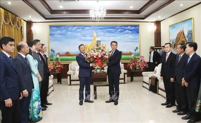 Vietnamese Ambassador Nguyen Minh Tam (L) presents a flower basket from Party General Secretary To Lam to the Lao People's Revolutionary Party to congratulate its 70th anniversary. (Photo: VNA)