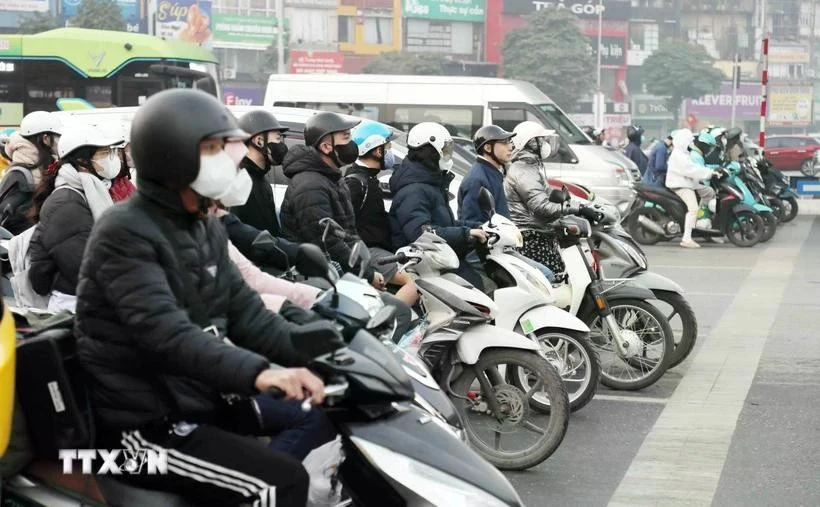 People stop at the red light on a street. (Photo: VNA)