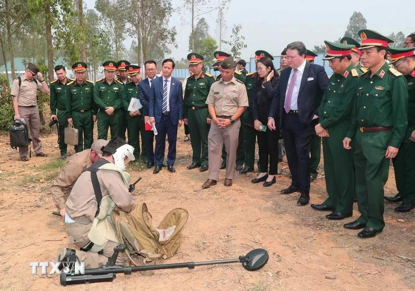 Delegates participnating the ceremony observe a demonstration of preparatory procedures before conducting bomb and mine clearance operations. (Photo: VNA) 
