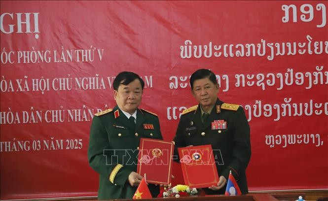 Deputy Defence Minister Senior Lieutenant General Hoang Xuan Chien (L) and his Lao counterpart Senior Lieutenant General Vongkham Phommakone exchange official minutes of the policy dialogue on March 28 (Photo: VNA)