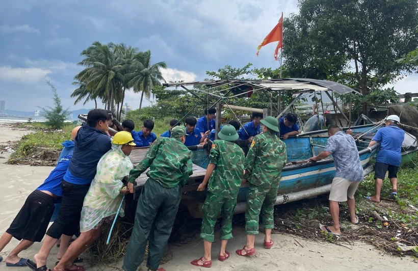 Youth union members in Lien Chieu district, Da Nang city, assist residents in bringing a basket boats ashore before a storm in October 2024. (Photo: VNA) 