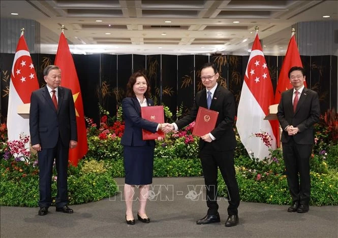 Party General Secretary To Lam (L) and Singaporean Prime Minister Lawrence Wong witness the exchange of the Letter of Intent on March 12. (Photo: VNA)