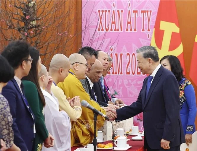 Party General Secretary To Lam (R) and participating overseas Vietnamese representatives at their meeting in Hanoi on January 19. (Photo: VNA)