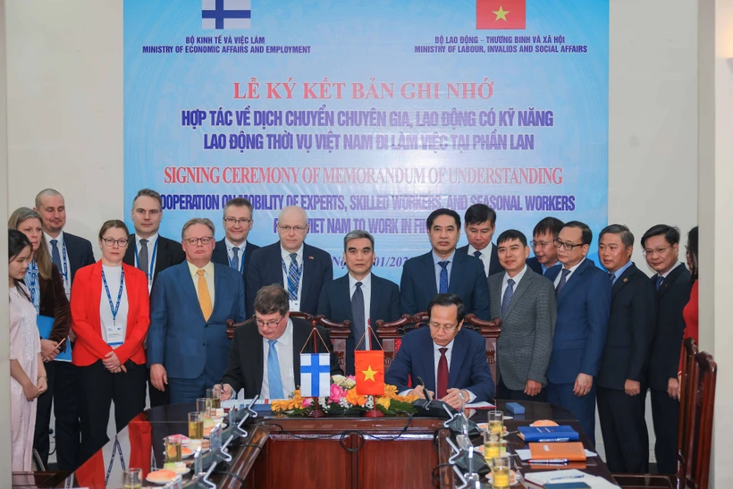 Minister of Labour, Invalids and Social Affairs Dao Ngoc Dung (R) and visiting Minister for Employment from the Finnish Ministry of Economic Affairs and Employment Arto Olavi Satonen sign a Memorandum of Understanding (MoU) on labour migration cooperation as part of their talks in Hanoi on January 13.(Photo: VNA)