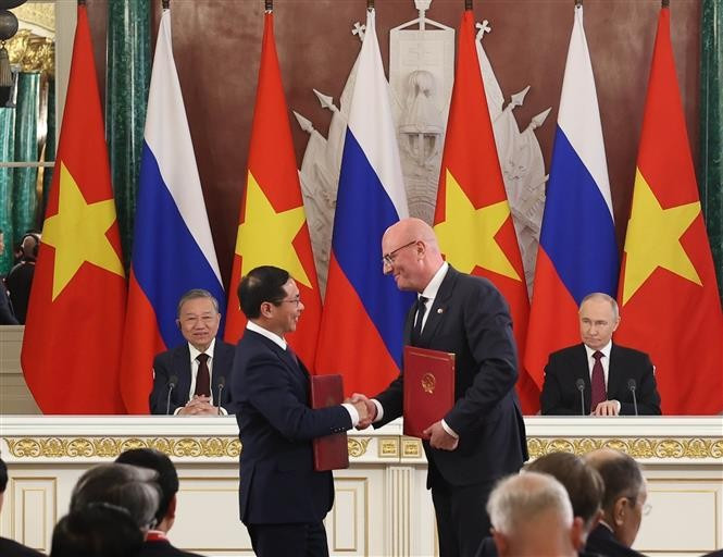 Party General Secretary To Lam and President Vladimir Putin witness Vietnamese Deputy Prime Minister and Minister of Foreign Affairs Bui Thanh Son (L) and Russian Deputy Prime Minister Dmitry Chernyshenko exchange the agreement on cooperation in the oil and gas sector and protocols governing the operations of the Vietsovpetro and Rusvietpetro joint ventures. (Photo: VNA)