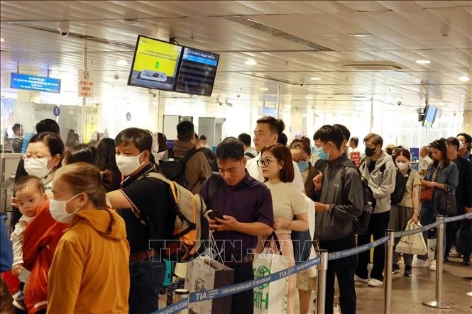 Passengers queue for security screening procedures at Tan Son Nhat Airport in HCM City. (Photo: VNA)