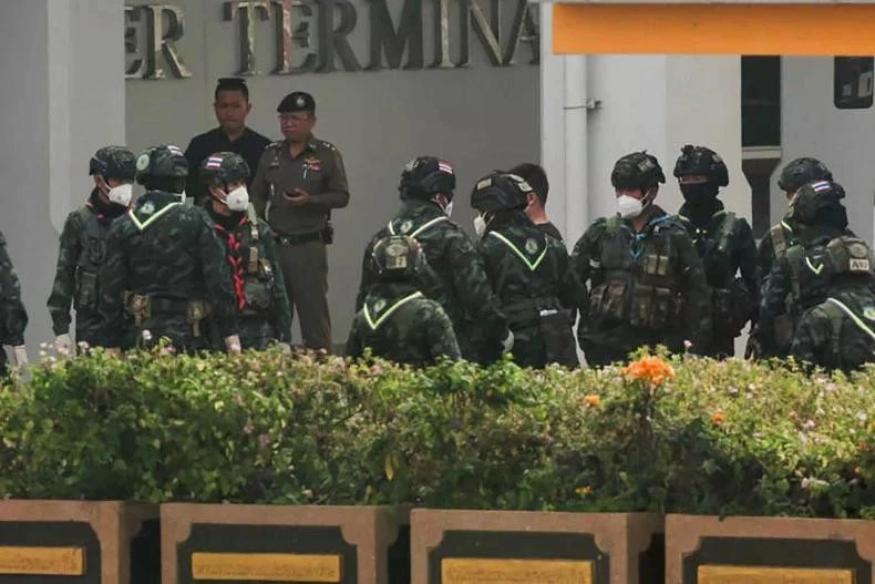 A Chinese national, who was taken from a scam centre in Myanmar amid a mounting crackdown on scammers operating along a porous border, is escorted by soldiers after getting off a bus at Thailand-Myanmar Friendship Bridge 2 before being repatriated to China by plane, in Mae Sot District, Tak province, Thailand on February 20, 2025. (Photo: bangkokpost.com)