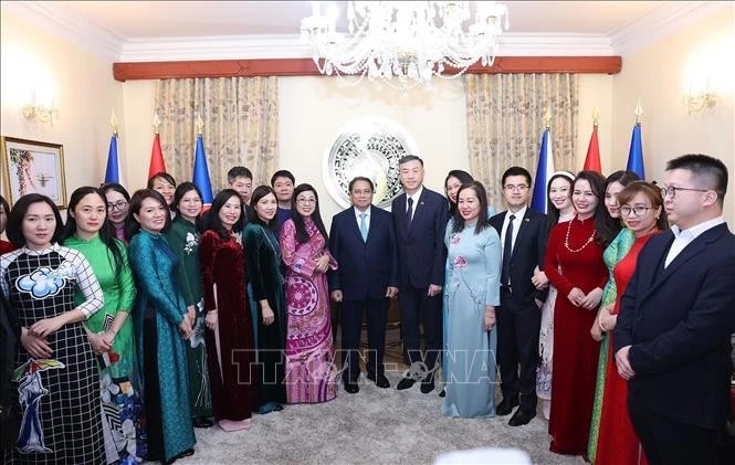 Prime Minister Pham Minh Chinh and his wife Le Thi Bich Tran in a group photo with staff of the Vietnamese Embassy in the Czech Republic on January 18 evening (local time). (Photo: VNA)