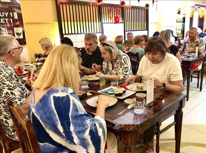 Foreign guests enjoy traditional Tet cuisine. (Photo: VNA)