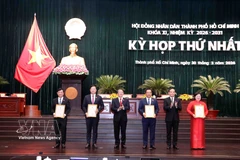 Politburo member and Secretary of the Ho Chi Minh City Party Committee Tran Luu Quang (second from right) and Vice Chairman of the National Assembly Nguyen Duc Hai (third from left) present certificates recognising members of the 11th-term Ho Chi Minh City People’s Council (2026–2031). (Photo: VNA) 