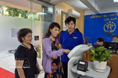 Citizens experience an AI-powered robot designed to assist with administrative procedures. (Photo: VNA)