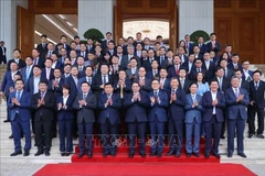 Prime Minister Pham Minh Chinh (centre, first row) poses for a photo with Vietnamese officials and leaders of Korean enterprises. (Photo: VNA)